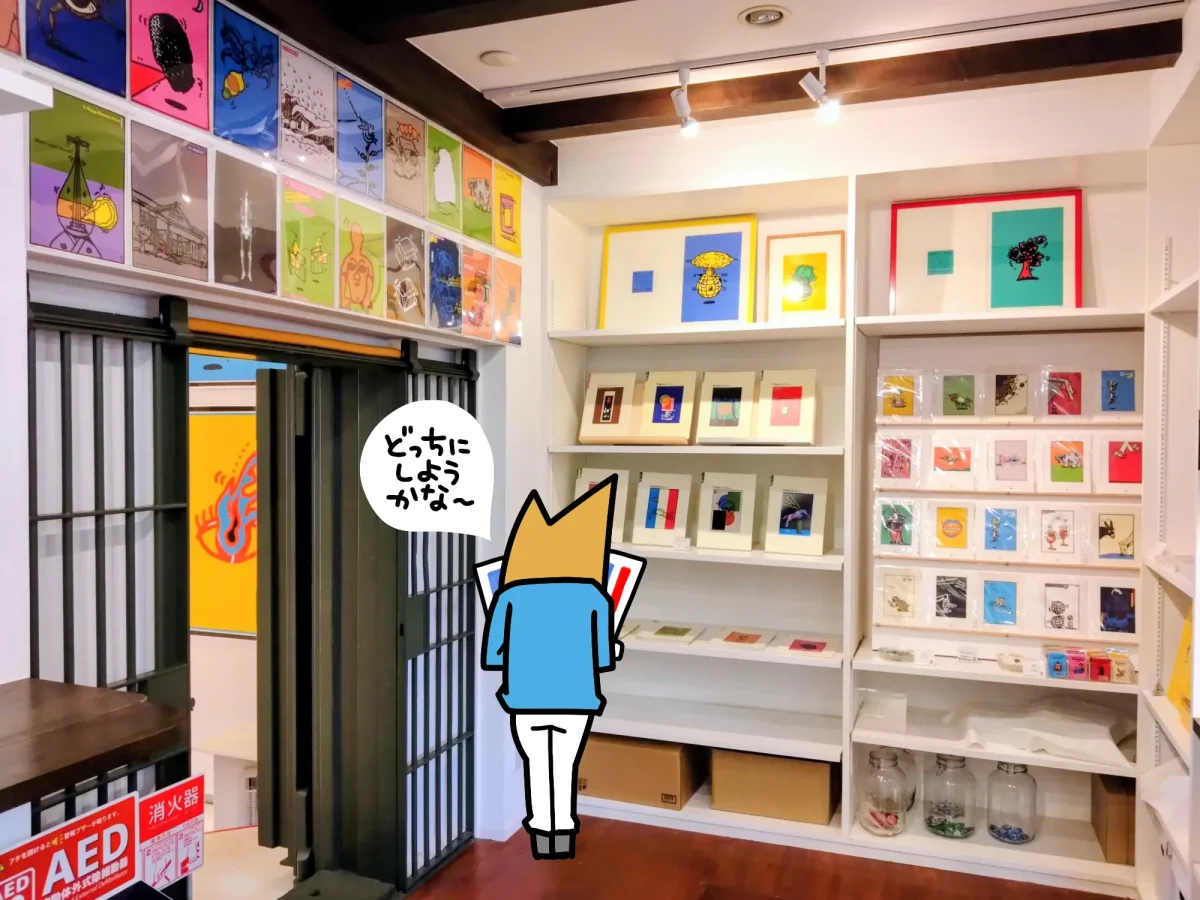 グッズ販売コーナーでポストカードを選ぶ様子