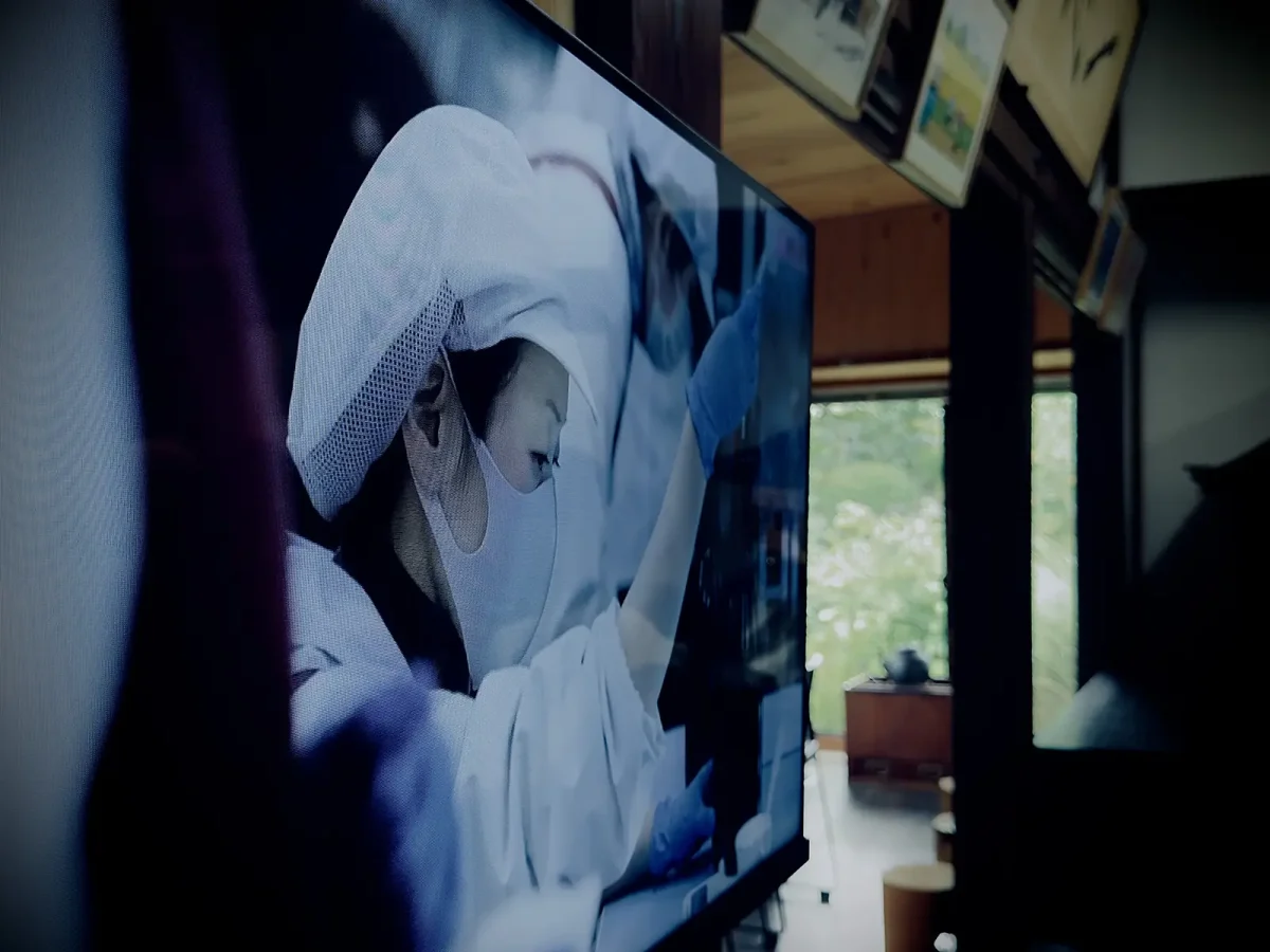 モニターに映る酒造りの職人の作業風景