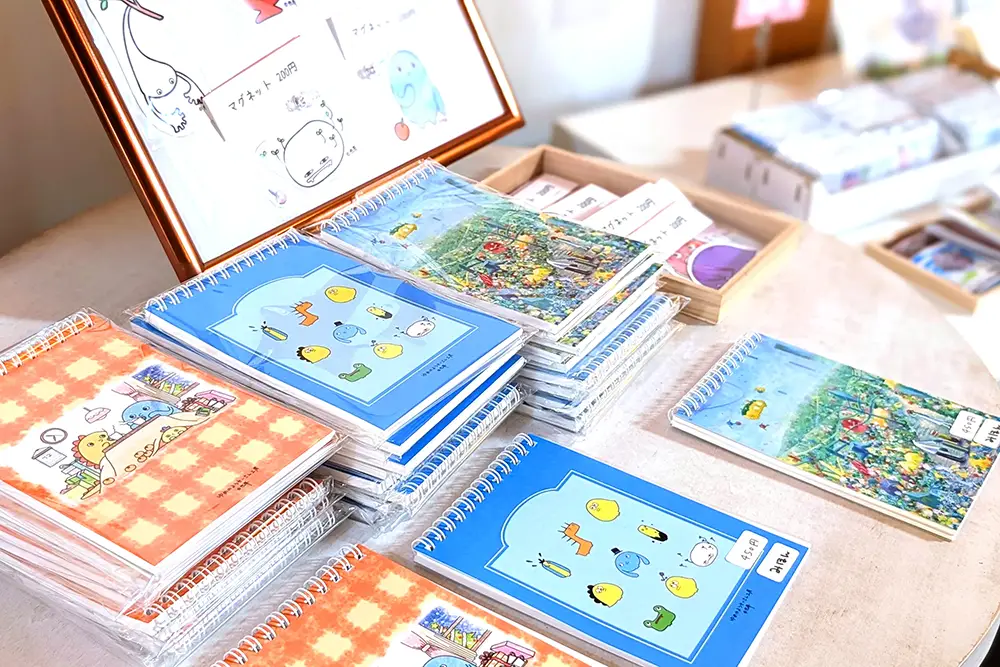 作品モチーフのノートやグッズが並ぶ様子