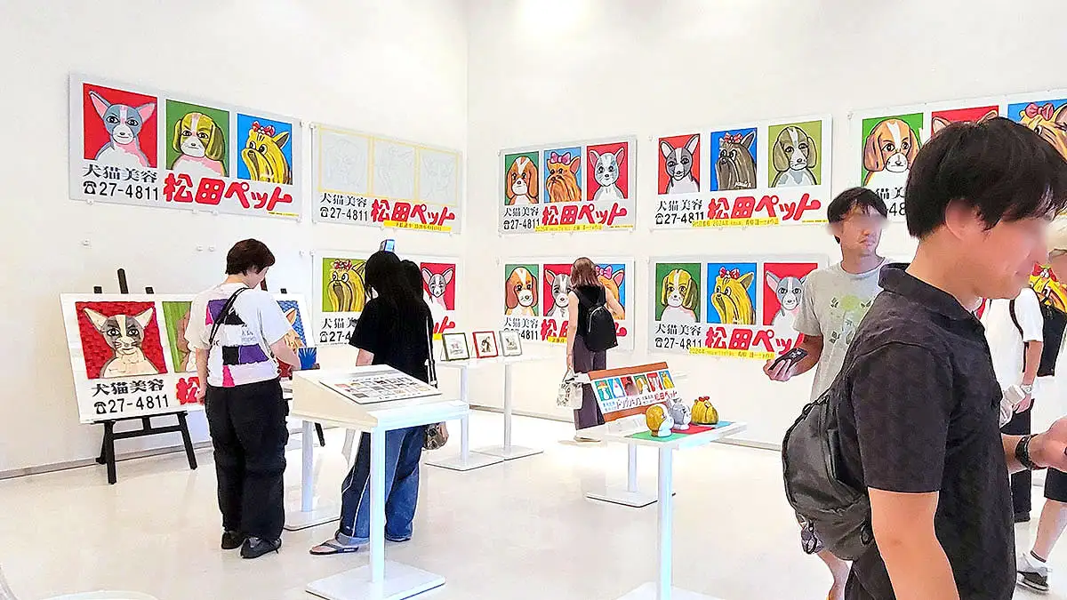 「例の看板展 – 松田三連星編 –」会場で松田ペットの犬看板を見る来場者