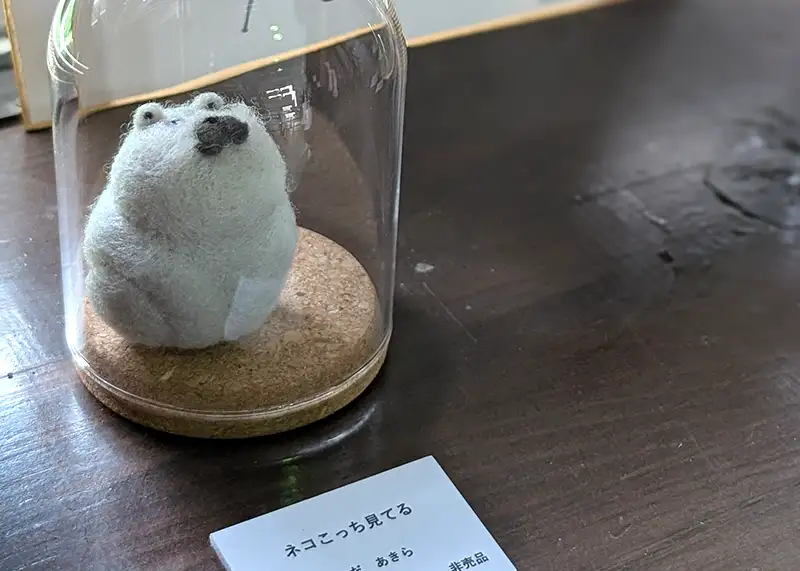 ガラスドームに収められた、かんだあきらさんの羊毛フェルト作品