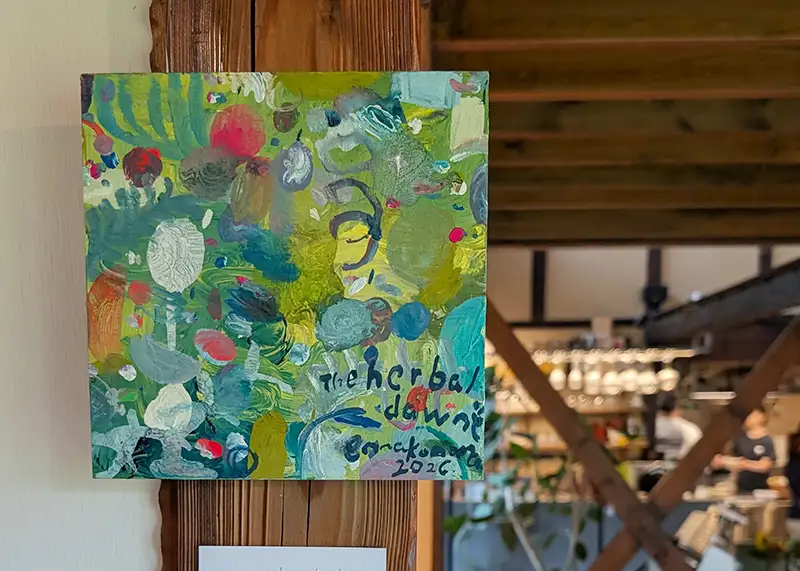 木の柱に展示されたennakonomaさんのカラフルな作品