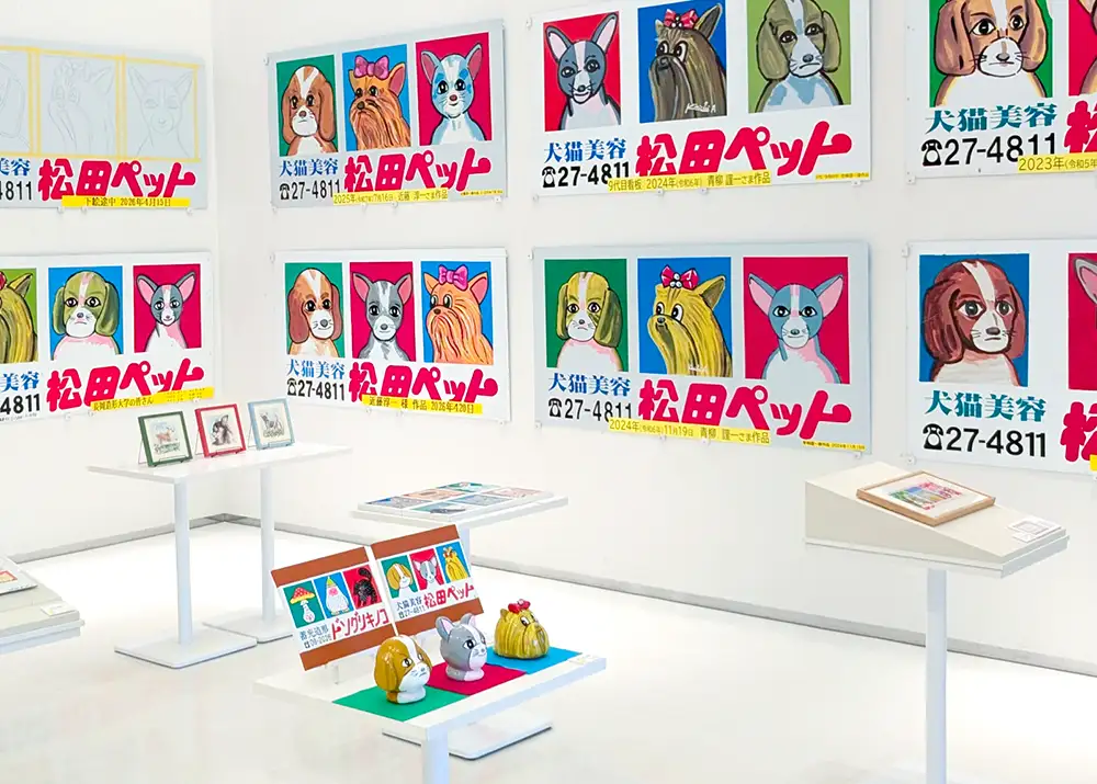 松田ペット三代の看板と地域作家によるオマージュ作品が並ぶ展示会場